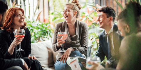 Group of people laughing with cocktails