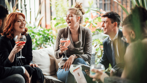 Group of people laughing with cocktails