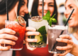 Three friends toasting while holding drinks