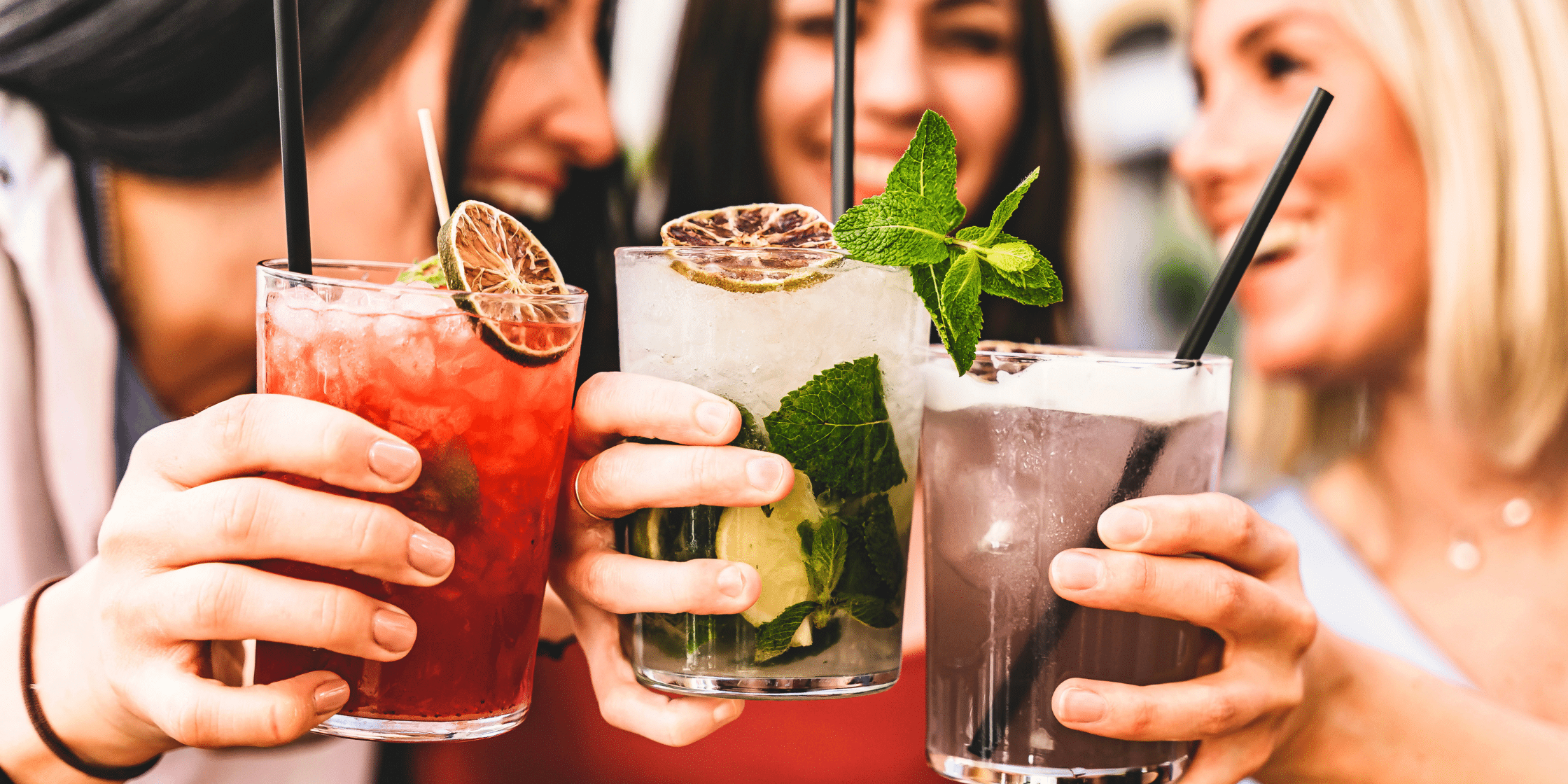 Three friends toasting while holding drinks