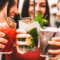 Three friends toasting while holding drinks