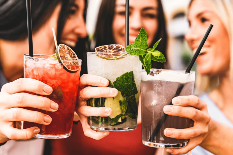 Three friends toasting while holding drinks